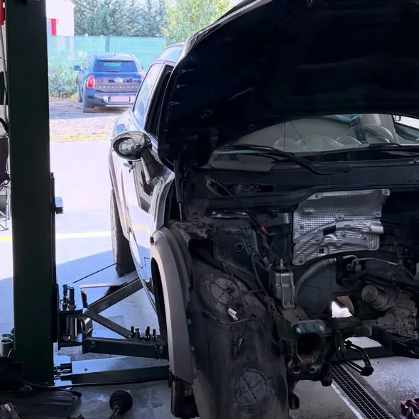 MINI Countryman R60 în atelier, cu capota ridicată și partea frontală demontată